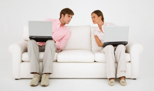Couple on couch with laptop computers
